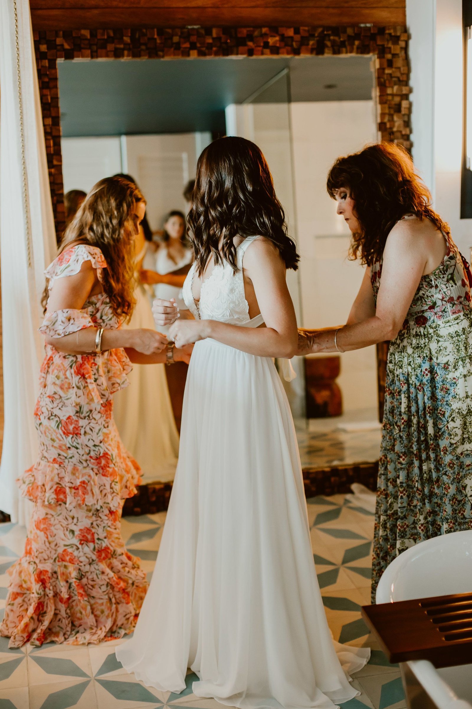 Bride getting her dress on inside her hotel room at The CApe in Cabo SAn Lucas Mexico