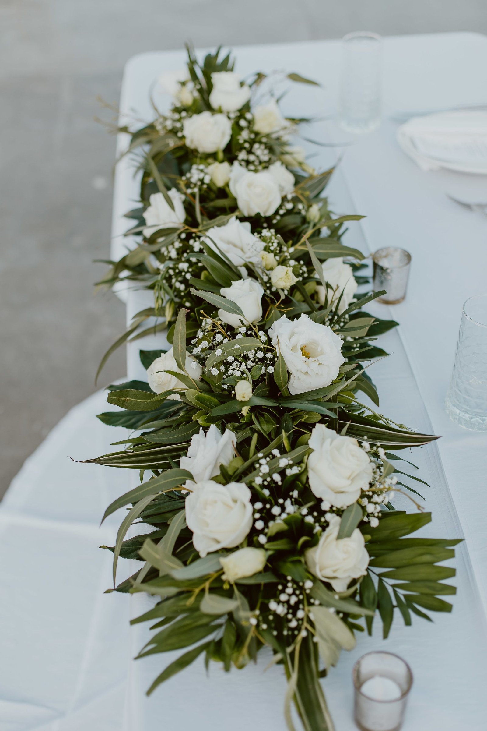 Table Centerpieces with greenery with White Flowers on Sweetheart Table at The Cape in Los Cabos Mexico