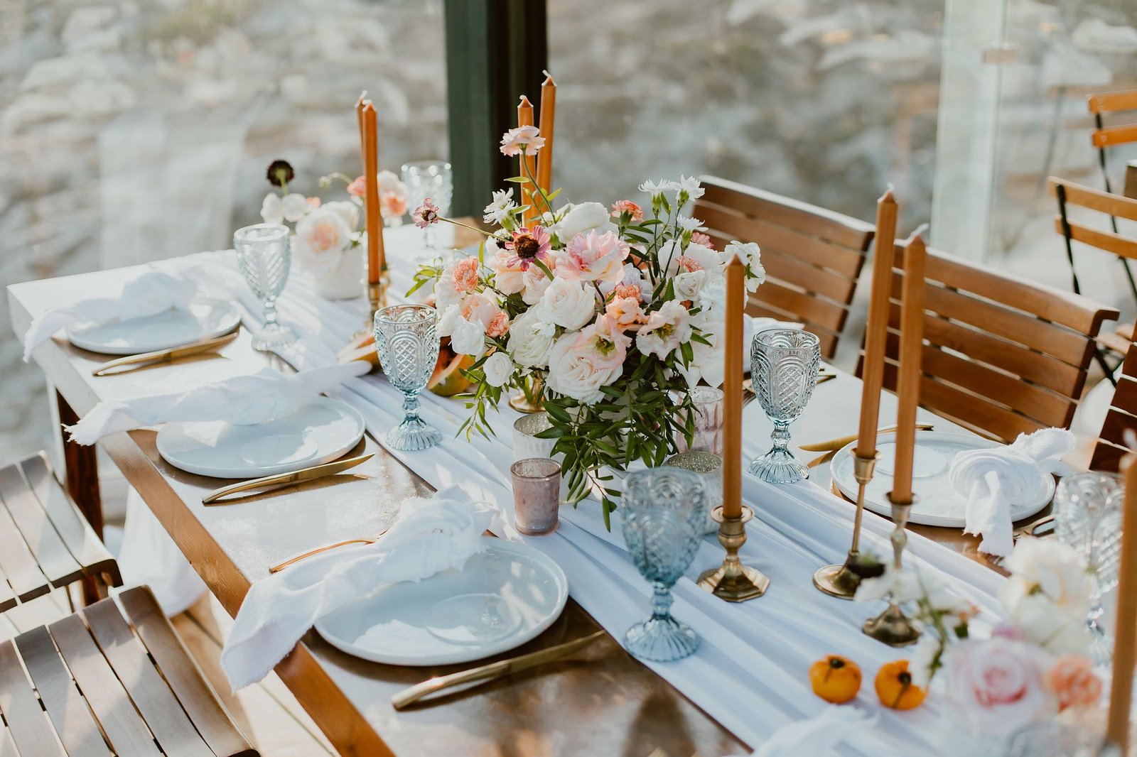 Table setup at the Rooftop at the Cape in Cabo San Lucas Mexico. There were Ranunculus, Peonies, Greenery and soft touches of flowers throughout the table, as well as fresh fruits such as lichees and papayas. Design by Lola from Florenta and wedding planning by Cabo Wedding Services