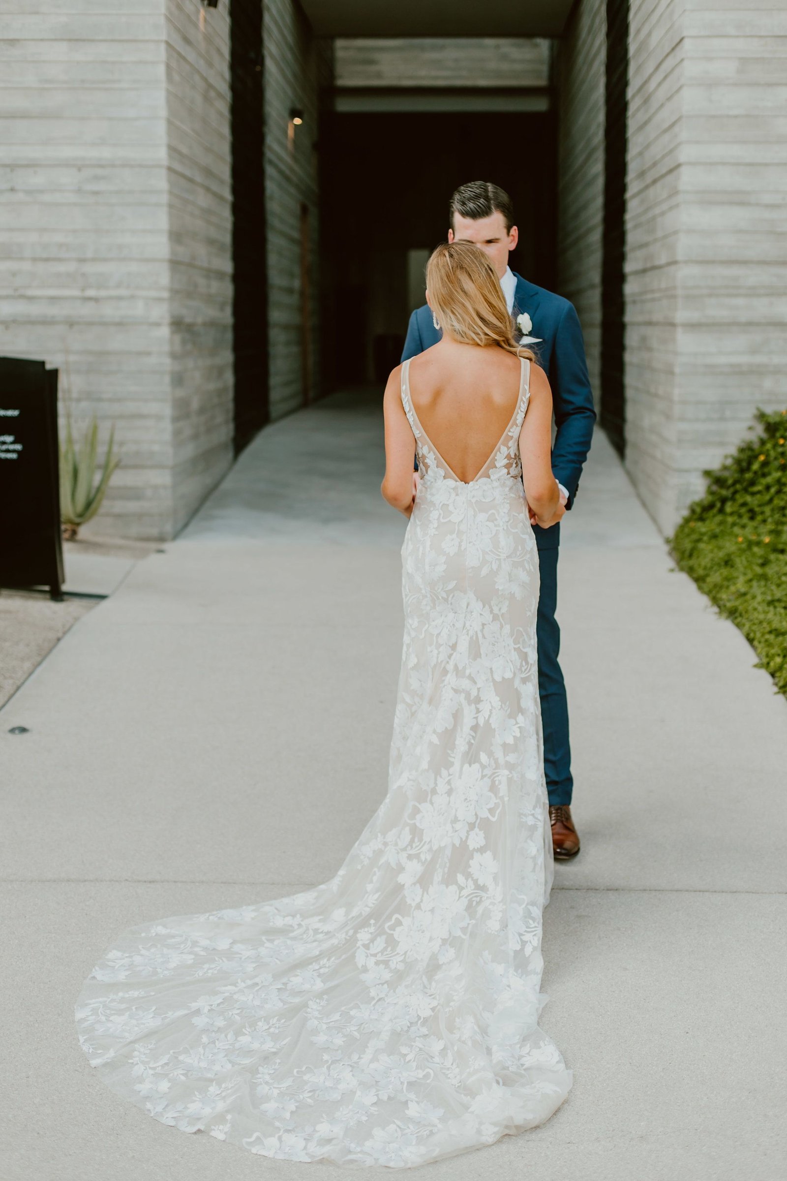 The groom sees the bride for the first time in her wedding dress that was made by Made with Love Bridal. This photo was taken at The Cape by Thompson Hotels in Cabo San Lucas Mexico. Wedding Planning by Cabo Wedding Services