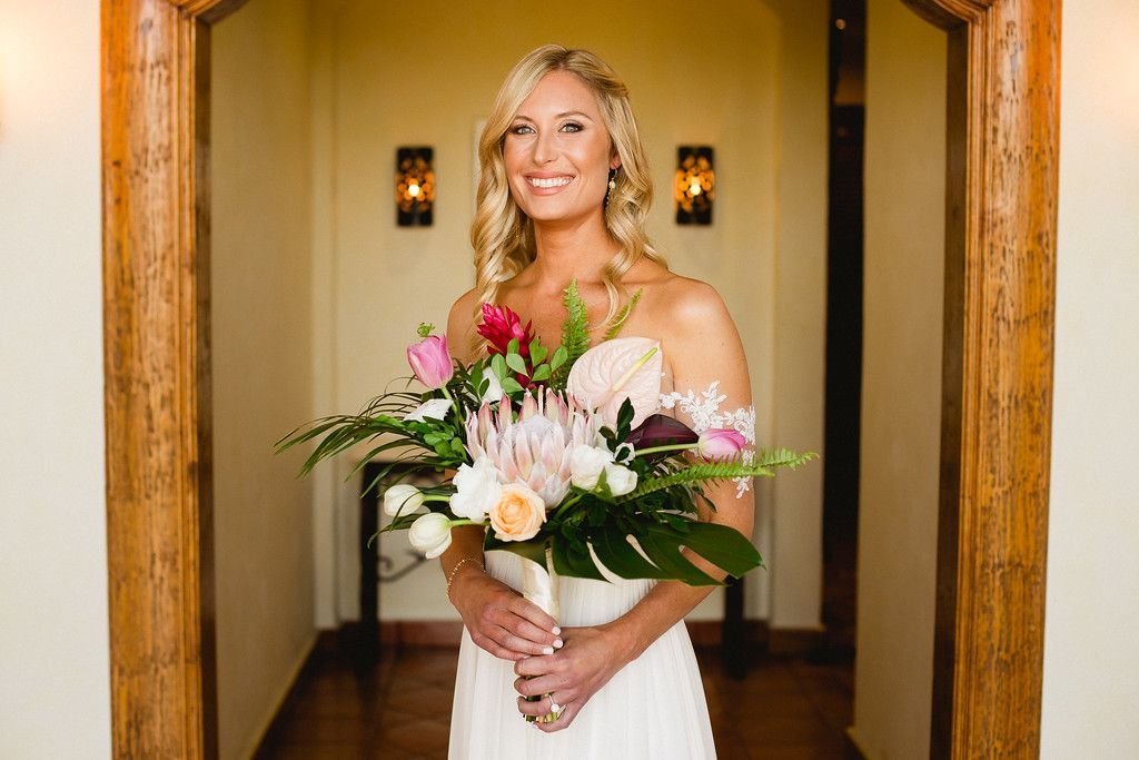 Bride Emily with her Tropical Bridal Bouquet wiht Proteas, Gingers, Anthuriums and tropical Greenery. Wedding Planner and designed by Cabo Wedding Services in Cabo San Lucas Mexico