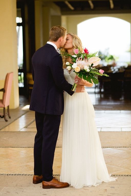 Bride and Groom giving eachother their first kiss after being all ready to walk down the aisle to get married at Cabo del Sol Club house in Cabo San Lucas Mexico