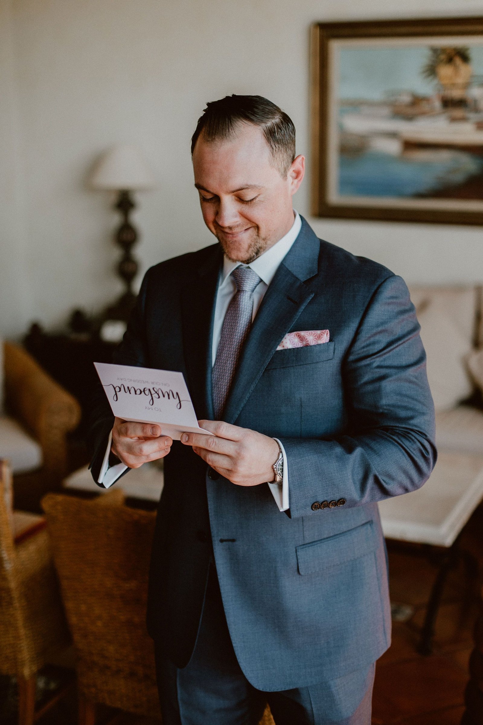 Groom reading the card his bride wrote to him right before the Wedding Ceremony on their wedding day. Their wedding was at Cabo del Sol, and we, Cabo Wedding Services were there Wedding Planners. They hired Ana and Jerome for their photography, and Emporio Floral Art for their Flowers.