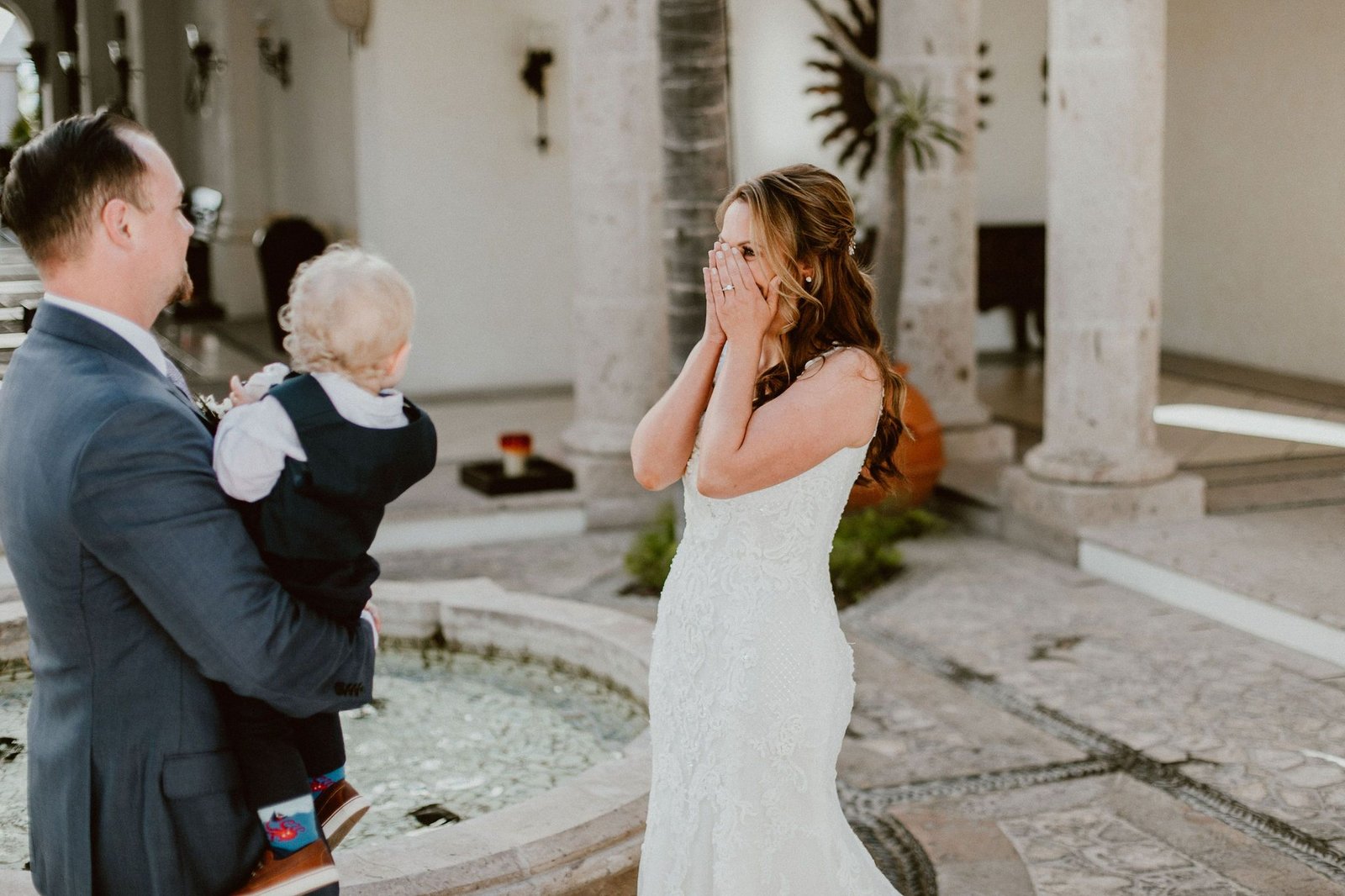 Bride and Groom doing their First Look. The Groom, Ian, was waiting for the Bride, Jen, to come down the stairs to see him and their son, Ryker, for the First time since she had her dress on. It was such an emotional and special moment. This wedding was in Los Cabos, Mexico. Wedding Planners Cabo Wedding Services, Ana and Jerome Photography, Emporio Floral Art for Flowers and Cabo del Sol Golf Club for Wedding Venue.