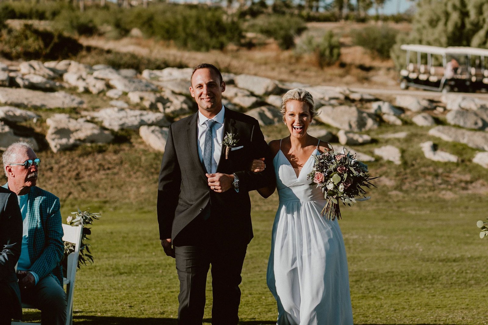 Bridesmaid and Groomsman walking down the Aisle for Jen and Ian's Wedding at Cabo Del Sol. Wedding Planning by Cabo Wedding Services and Photography by Ana and Jerome. 