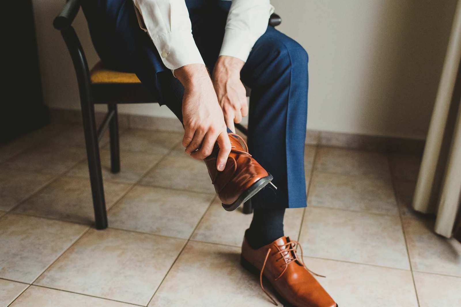 Groom getting ready in his hotel room at Villa del Palmar in Los Cabos Mexico. He decided to go with a navy blue suit with some light brown dress shoes. He looked very handsome standing up at the ceremony with his groomsmen.