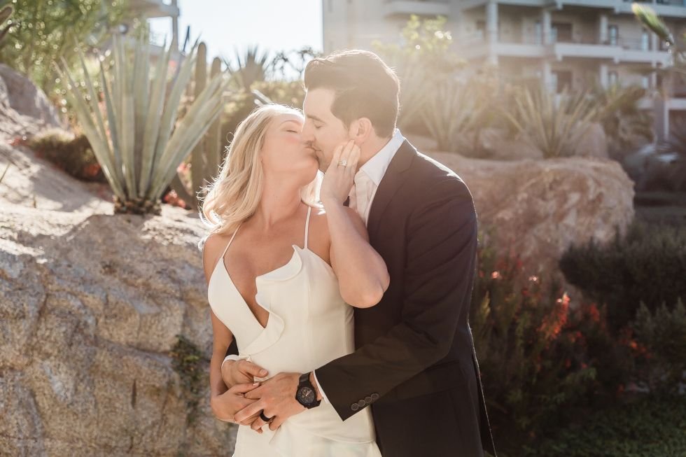 Bride and Groom kissing at The Cape by Thompson Hotels in Los Cabos, Mexico. Wedding Planning by Cabo Wedding Services.