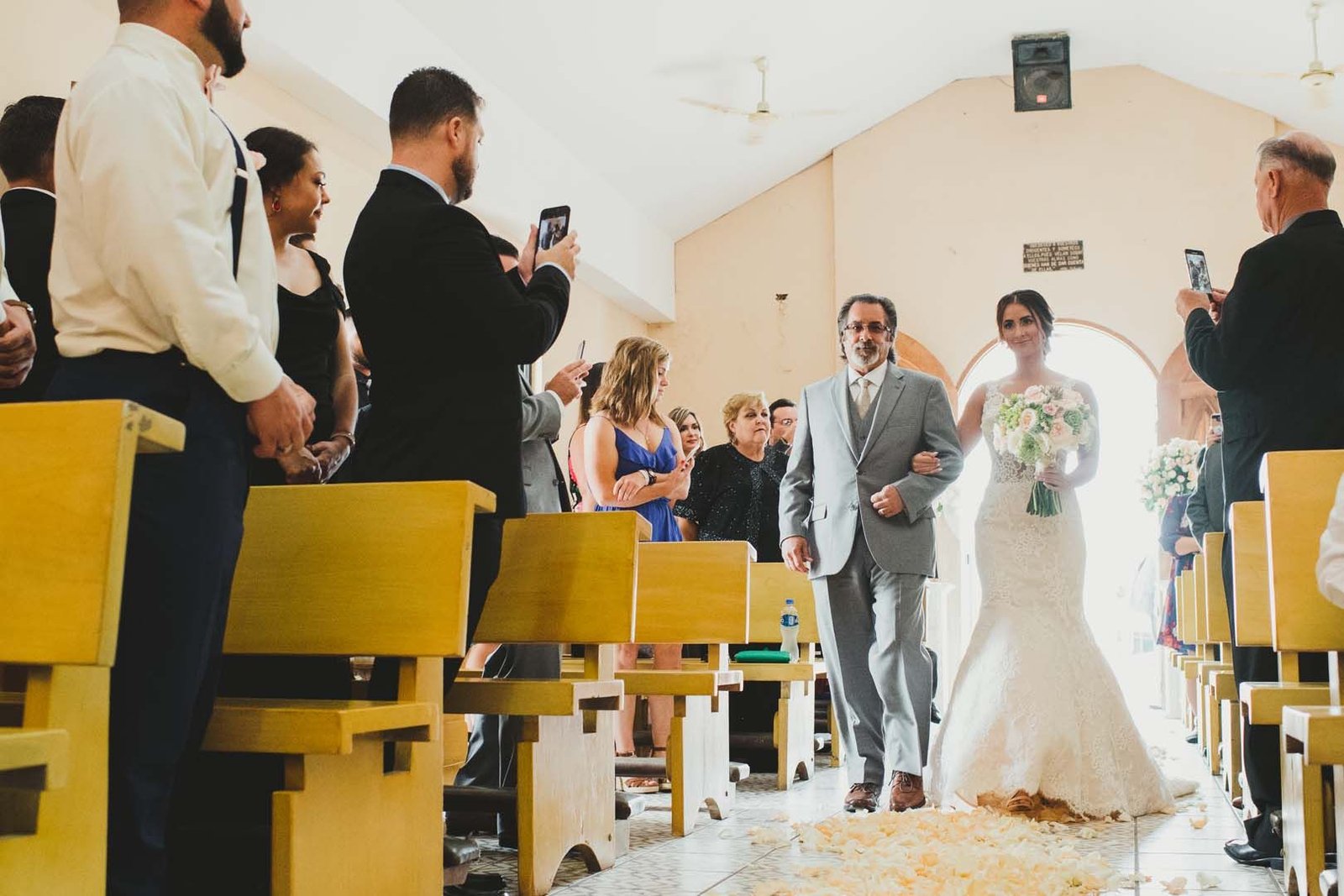 Bride walking down the Aisle in a Catholic Church in Los Cabos, Mexico. It was one of the prettiest weddings we had seen at this church. Wedding Planning by Cabo Wedding Services