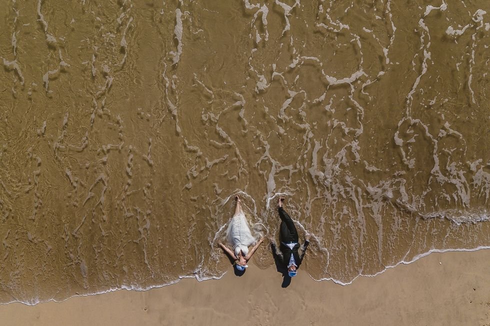 Bride and Groom laying in the sand for their trash the dress session. So much fun for them. They hired local Photographer Daniel Jireh.