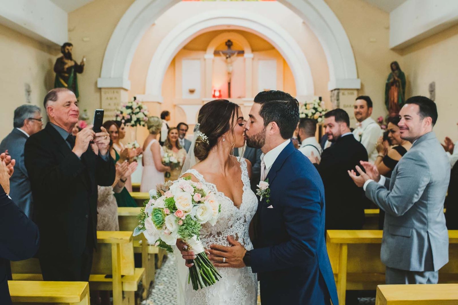 Bride and Groom kissing each other right after their wedding ceremony in front of their closest family and friends during their wedding.