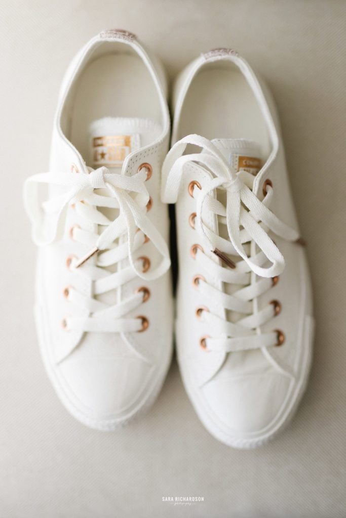 Brides wedding shoes. She wanted to go comfortable in Converse Tennis Shoes and got the cutest white ones with gold touches.