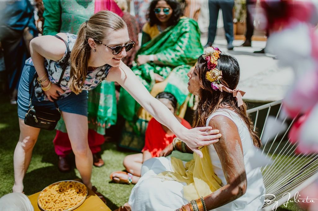 One guest coming up to the Bride to put turmeric on her.