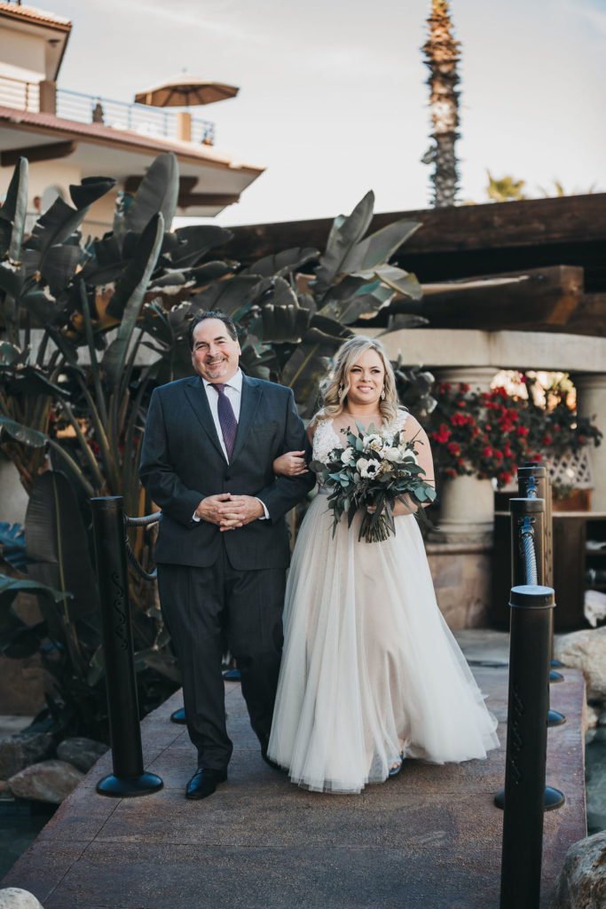 Bride walking down the aisle with her Father, at Villa Group. This was a Destination Wedding that took place in Los Cabos, Mexico. Wedding Planning was done by Cabo Wedding Services.