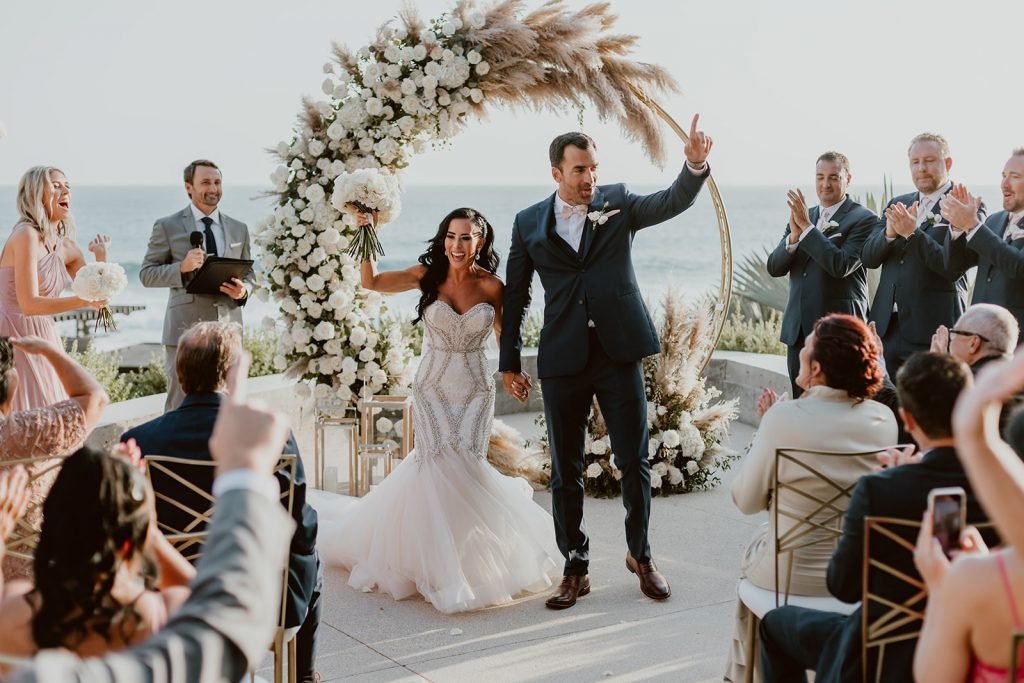 Bride and Groom doing the recessional, right after the ceremony when they were announced husband and wife, at The Cape in Los Cabos, Mexico. Wedding planning was done by Cabo Wedding Services