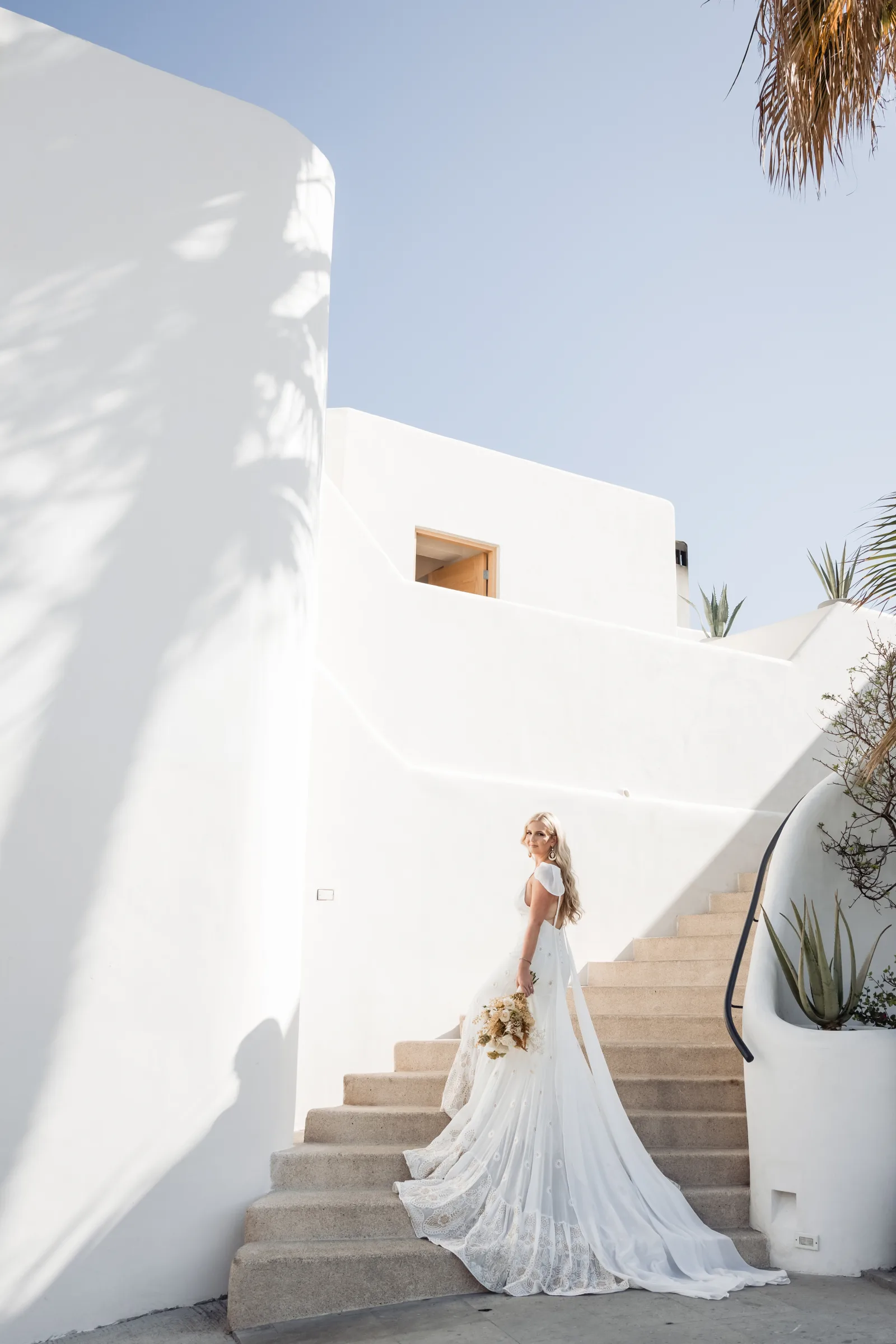 Bride walking down white stairs at a resort in Cabo San Lucas