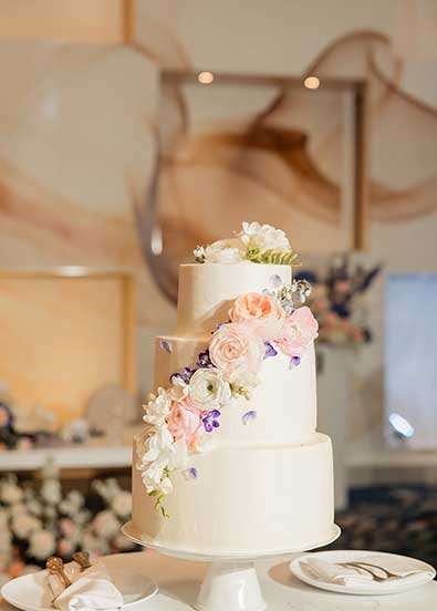 A wedding cake decorated with tropical flowers.