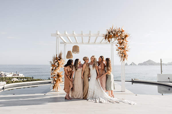 Sunset Monalisa wedding setup in Cabo San Lucas — couple on cliffside terrace at sunset